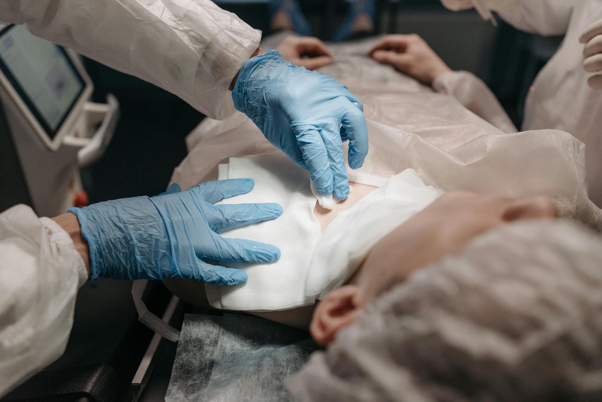 Doctors perform a medical procedure in a sterile environment, focusing on precision and care.