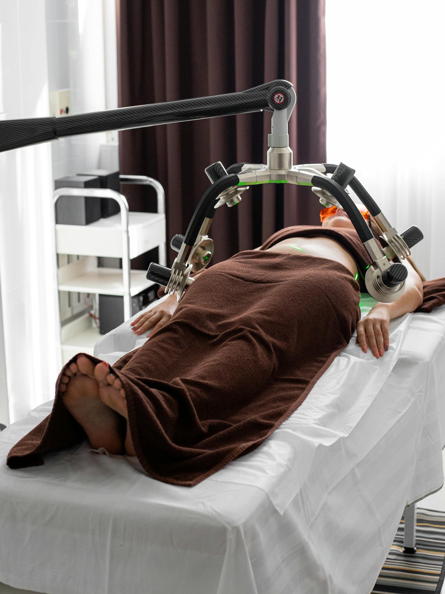 Female patient undergoing a contemporary laser treatment for weight loss in a medical clinic.